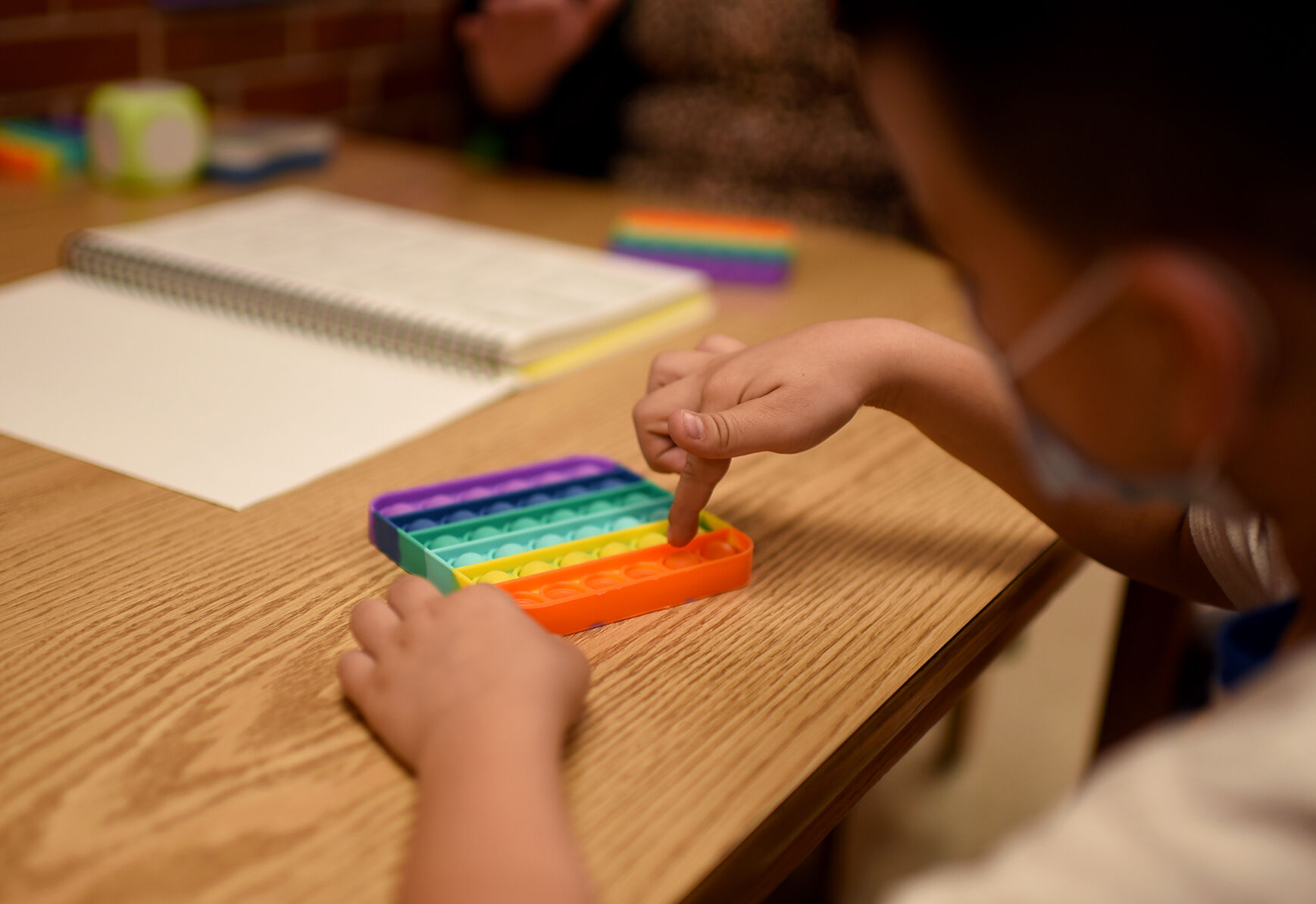First grade student Jesus Rodriguez presses a pop-it toy bubble